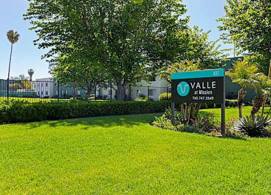A green sign with the word "Valle" on it is in front of a building.