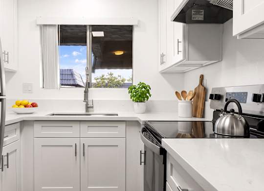 A modern kitchen with white cabinets and a stainless steel refrigerator.