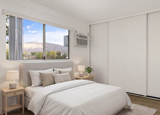 A bedroom with a large bed and a window overlooking a mountain.