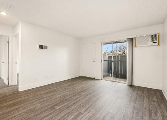 A room with a sliding glass door leading to a balcony.