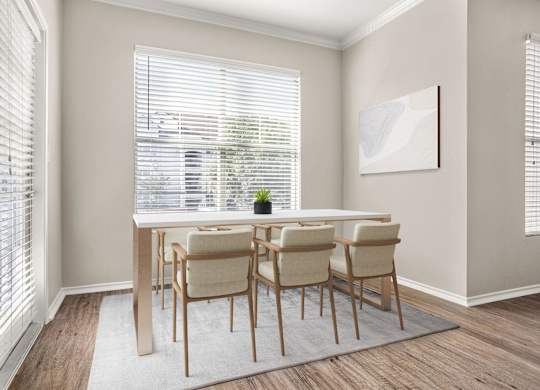 A dining room with a table and chairs.
