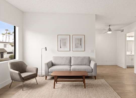 A living room with a grey couch, a chair, and a table.