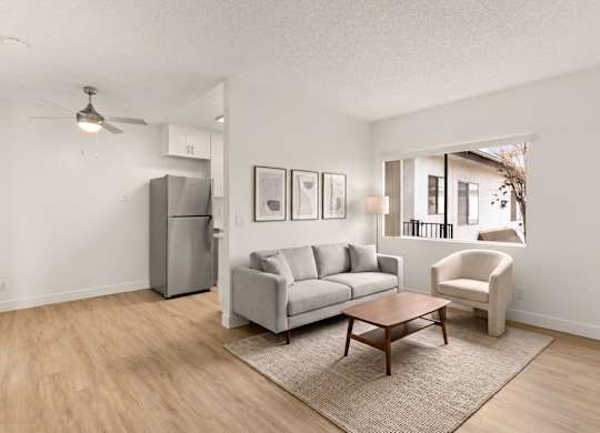 A living room with a grey couch, a brown coffee table, and a white chair.