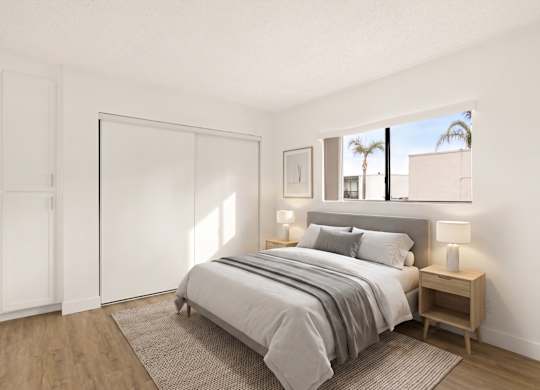 A bedroom with a bed, nightstand, and a window.