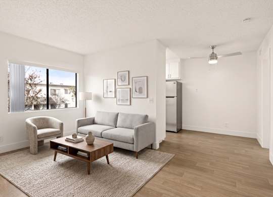 A living room with a grey couch, a brown coffee table, and a white chair.