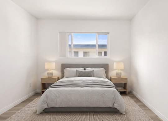 A bedroom with a large bed and two lamps.