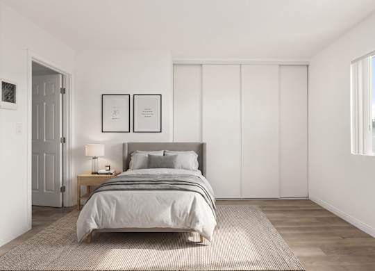A bedroom with a bed, nightstand, and two picture frames on the wall.