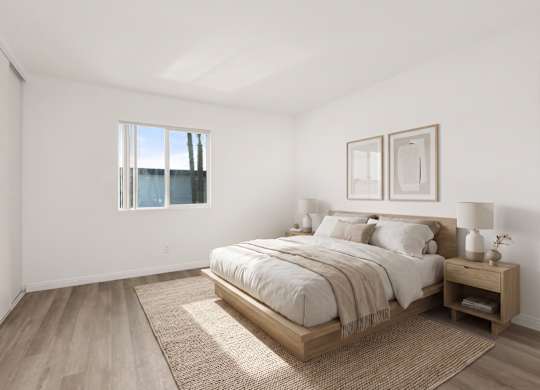 A bedroom with a large bed and a window.