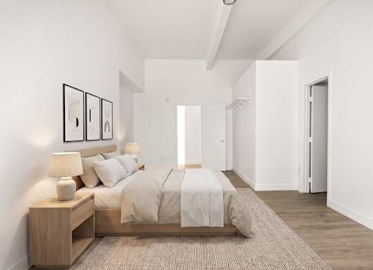 A bedroom with a bed, nightstand, and pictures on the wall.