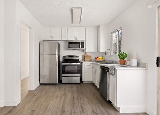 A kitchen with white cabinets and stainless steel appliances.