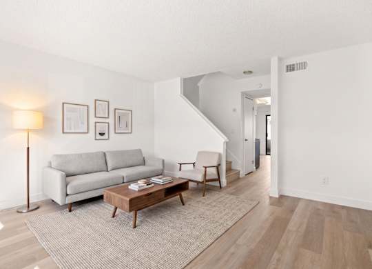 A living room with a grey couch and a wooden coffee table.