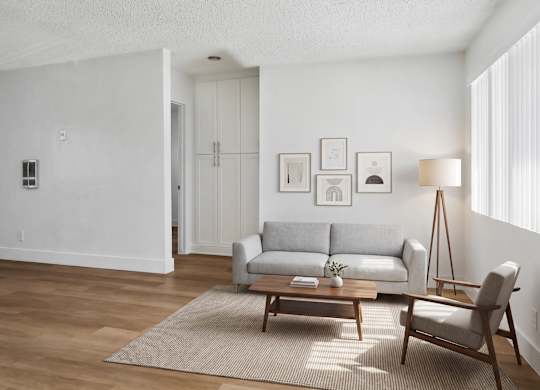 A living room with a grey couch, a wooden coffee table, and a lamp.