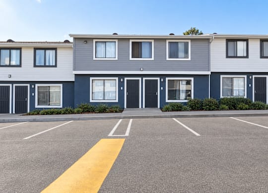 A parking lot in front of a row of townhouses.