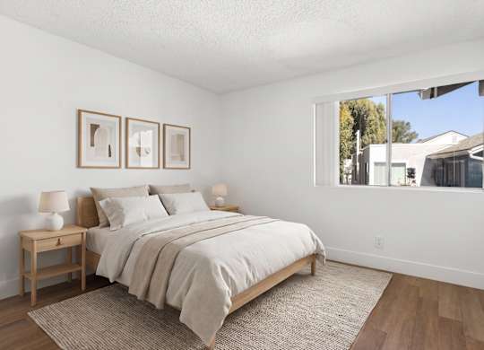 A bedroom with a large bed and two nightstands.