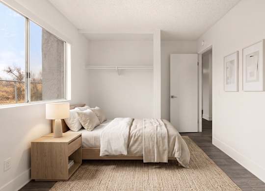 A bedroom with a bed, nightstand, and two pictures on the wall.