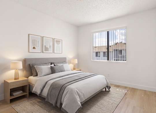 A bedroom with a large bed, two lamps, and two pictures on the wall.