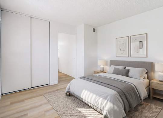 A bedroom with a bed, nightstands, and a wardrobe.