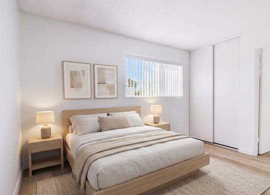 A bedroom with a large bed and two nightstands.