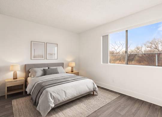 A bedroom with a large bed and two lamps on side tables.