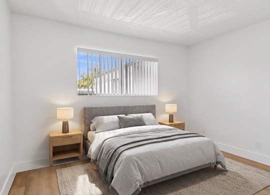 A bedroom with a large bed and two lamps on side tables.