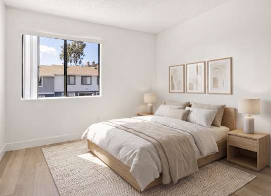 A bedroom with a large bed and a window overlooking a building.