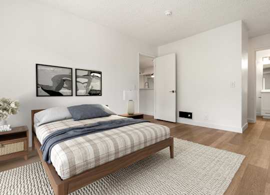 A bedroom with a bed, nightstand, and two framed pictures on the wall.