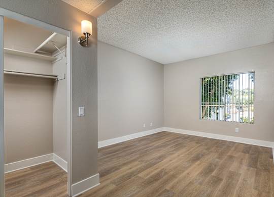 Empty room with wood flooring and a window.