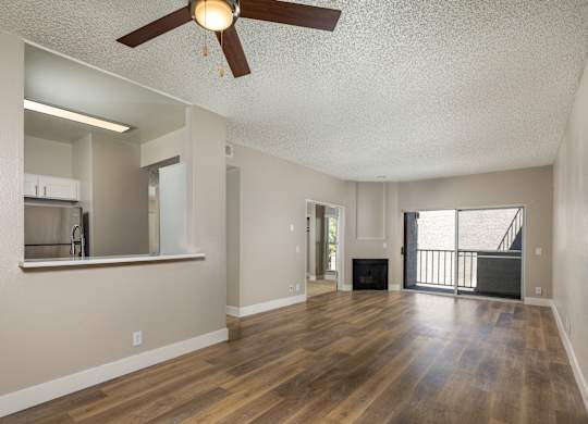 A room with a ceiling fan and wooden floors.