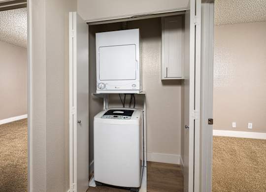 A white dryer and washer are in a small utility closet.