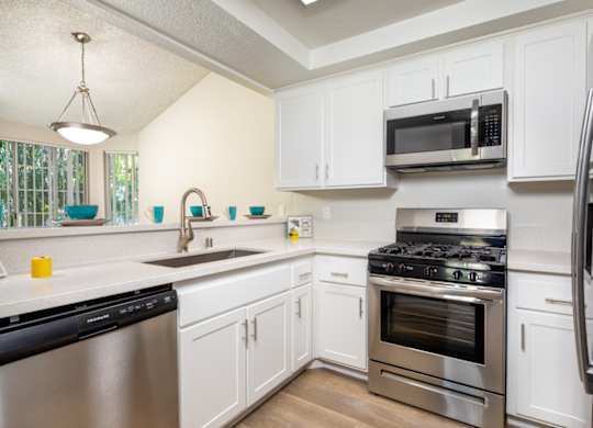 A kitchen with white cabinets and stainless steel appliances.