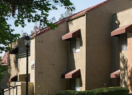 A building with beige walls and red awnings.