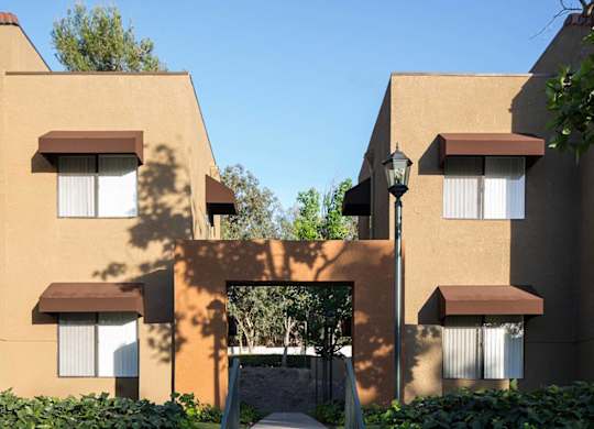 A building with brown and beige walls and white windows.