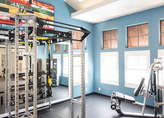 A gym with a blue wall and a variety of equipment.