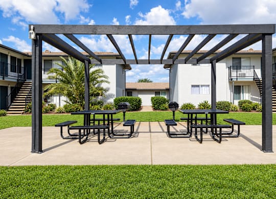 A patio with a table and chairs under a pergola.