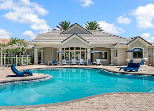 A house with a pool in front of it.