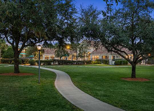 A pathway leads through a grassy area with trees on either side.