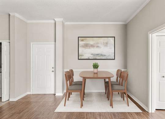 A dining room with a table and chairs.