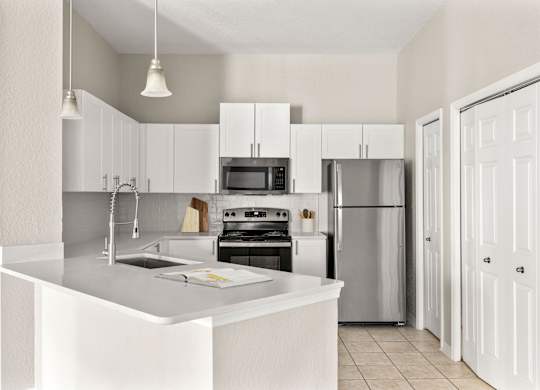 A modern kitchen with white cabinets and appliances.