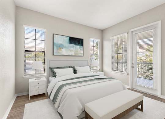 A bedroom with a large bed, a nightstand, a bench, and a painting on the wall.