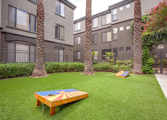 A small backyard with a trampoline and a slide.