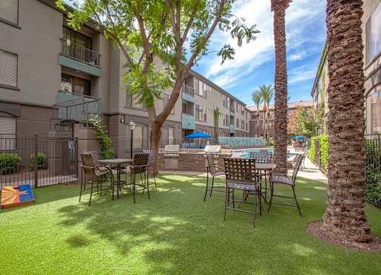 A patio with a table and chairs surrounded by apartment buildings.