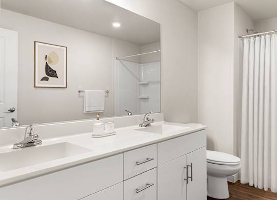 A white bathroom with a toilet, sink, and mirror.