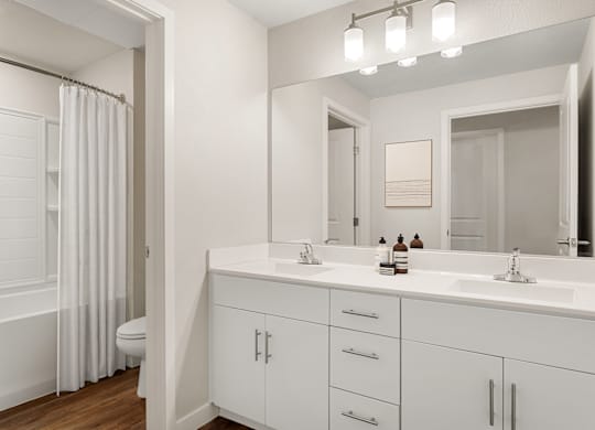 A white bathroom with a toilet, sink, and mirror.
