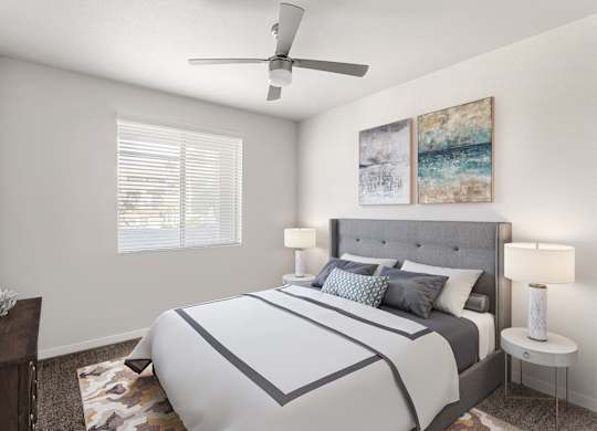 A bedroom with a large bed and a ceiling fan.