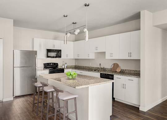 A kitchen with white cabinets and a granite countertop.