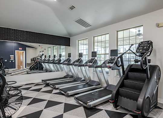 A gym with treadmills and elliptical machines.