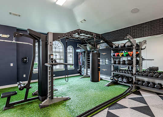 A gym with a green artificial turf floor and a black and white checkered floor.