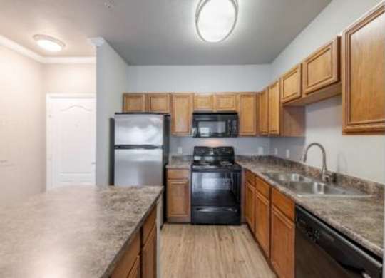 A kitchen with a black stove top oven and wooden cabinets.