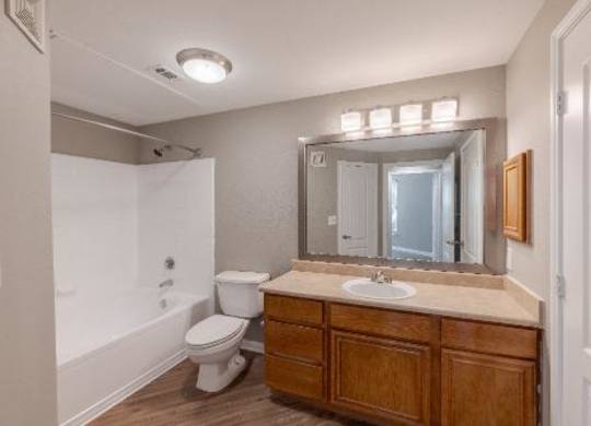 A bathroom with a toilet, sink, and mirror.