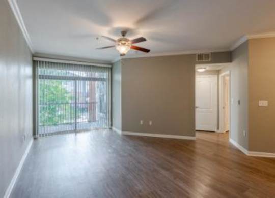 A room with a sliding glass door leading to a balcony.